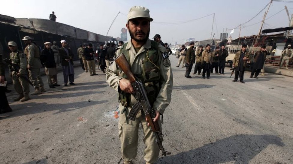 Сотрудник пакистанских служб безопасности на месте взрыва бомбы на блокпосту военизированных формирований на окраине Пешавара (19 января 2016 г.)