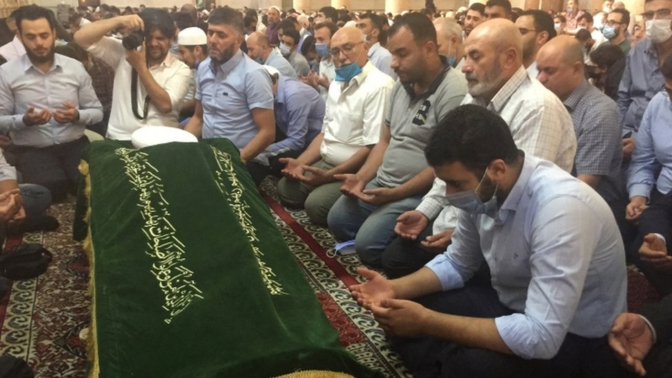 Mourners with the coffin of Sheikh Afiyuni