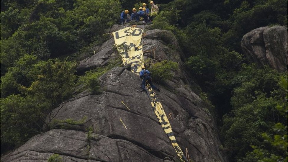 Гигантское знамя демократии на холме Гонконг перед визитом главы государства Китая