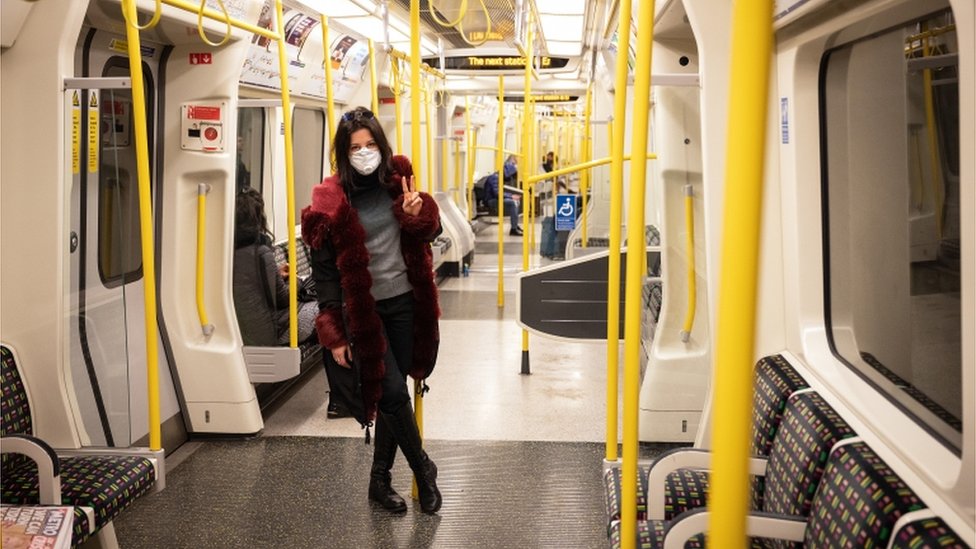 Женщина в защитной маске едет в метро в Лондоне