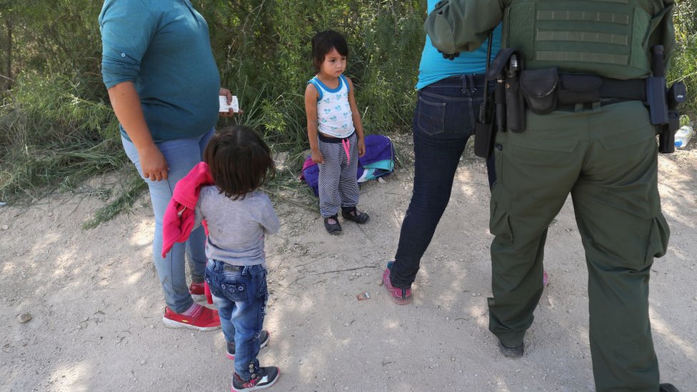 Guardas fronterizos detienen a mujeres centroamericanas con sus hijos.