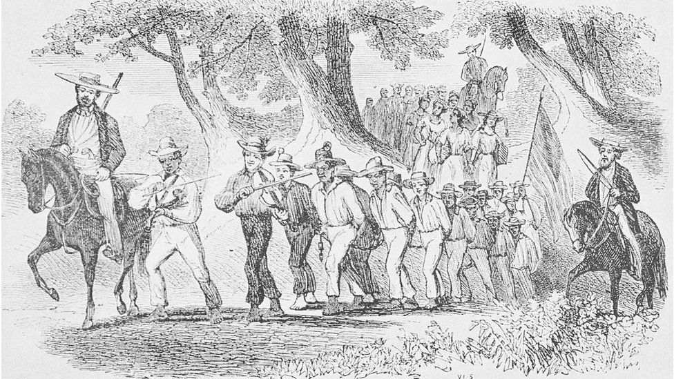Ellerini bağladıkları bir grup köleyi yürüten ve ellerinde silahlarla kırbaçlar bulunan atlılar