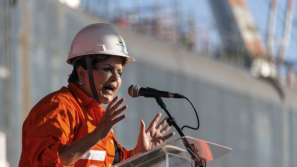 Dilma Rousseff vestindo macacão e capacete da Petrobras durante encontro com petroleiros em 2011