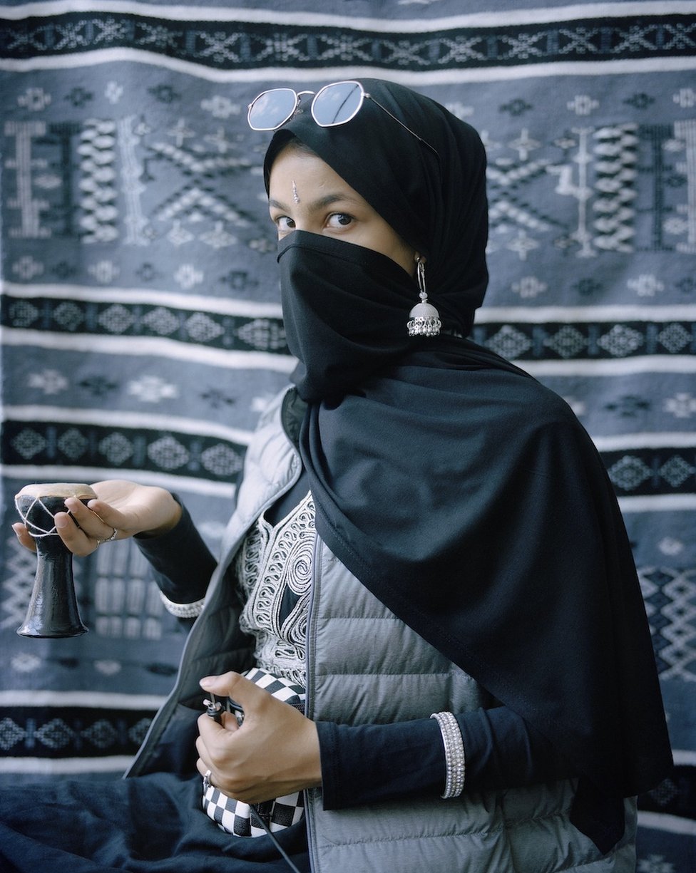 Портрет женщины в различной культурной одежде, смотрящей в камеру