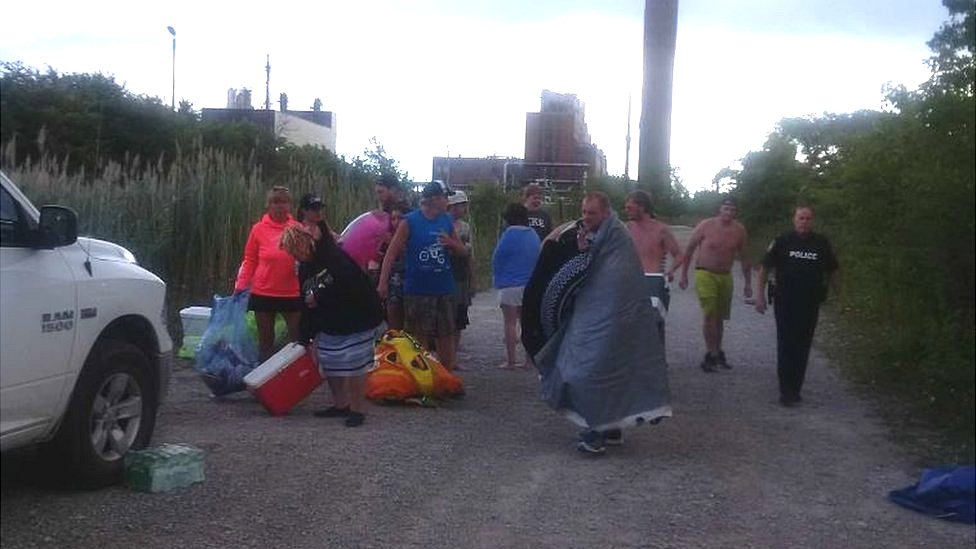 Полиция Сарнии, Онтарио, опубликовала в Твиттере фотографию американских лодочников после того, как они были спасены на реке Сент-Клер.