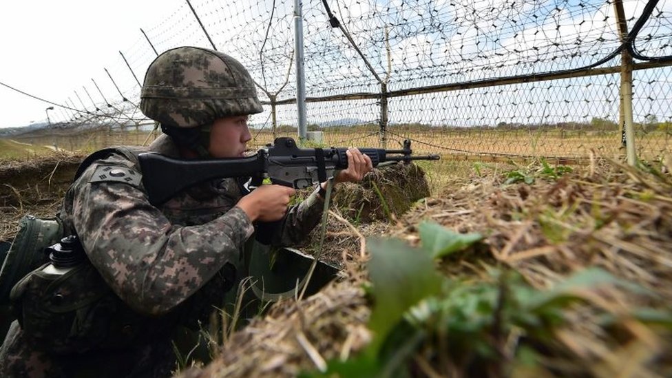 Южнокорейский солдат стоит на страже перед военным забором на Главной заставе (GOP) демилитаризованной зоны, разделяющей две Кореи в Чорвоне, 13 октября 2015 года.