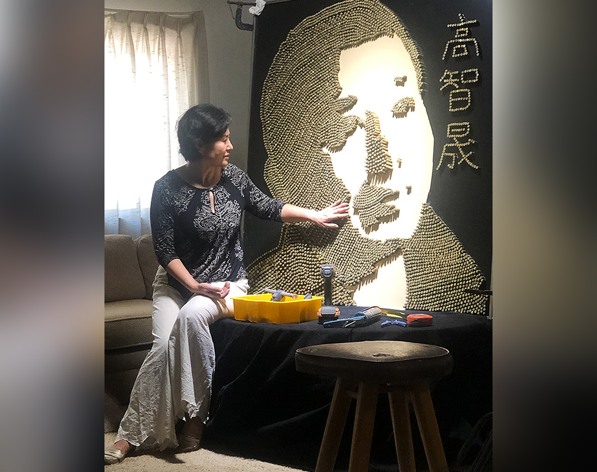 Geng He mostrando un retrato de su esposo.