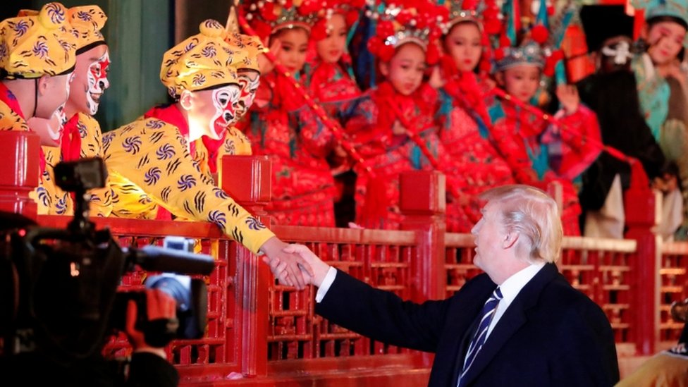 Президент США Дональд Трамп пожимает руку оперному артисту в Пекине