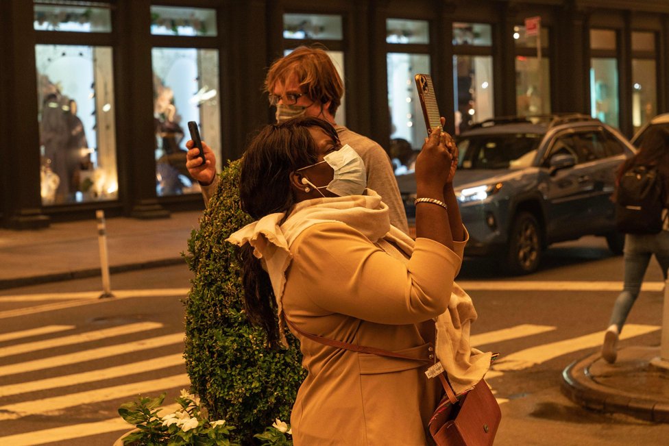Personas con tapabocas toman fotos en downtown Manhattan el 7 de junio de 2023.