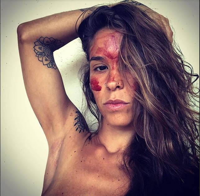 A picture showing Morena Cardoso with her face painted in menstrual blood