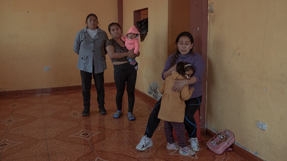 Синтия Эстрада Боливар (31) и ее трехлетняя дочь в своем доме в сопровождении родственников