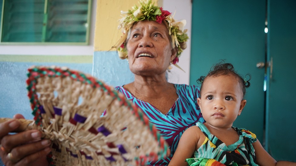 Una mujer con una niña en brazos en Tuvalu