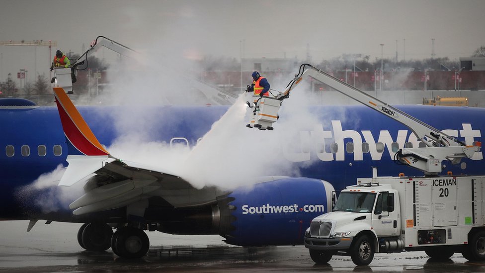Workers de-ice a Southwest Airline's aircraft at Midway Airport