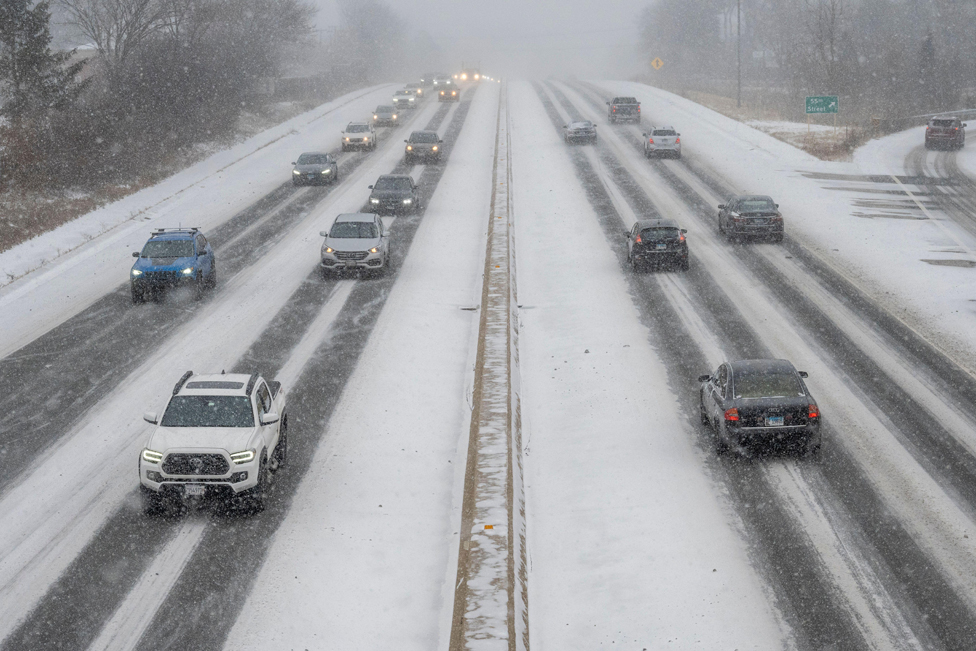 Traffic passes as heavy snowfall begins in a western suburb of Chicago, 22 December 2022