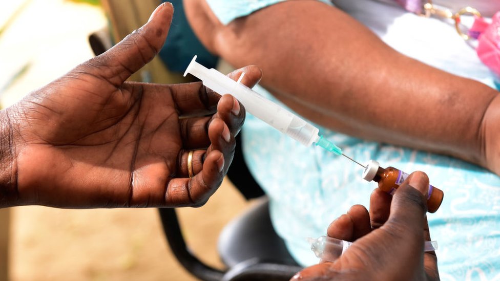 Медсестра готовится сделать прививку от кори в Сенегале