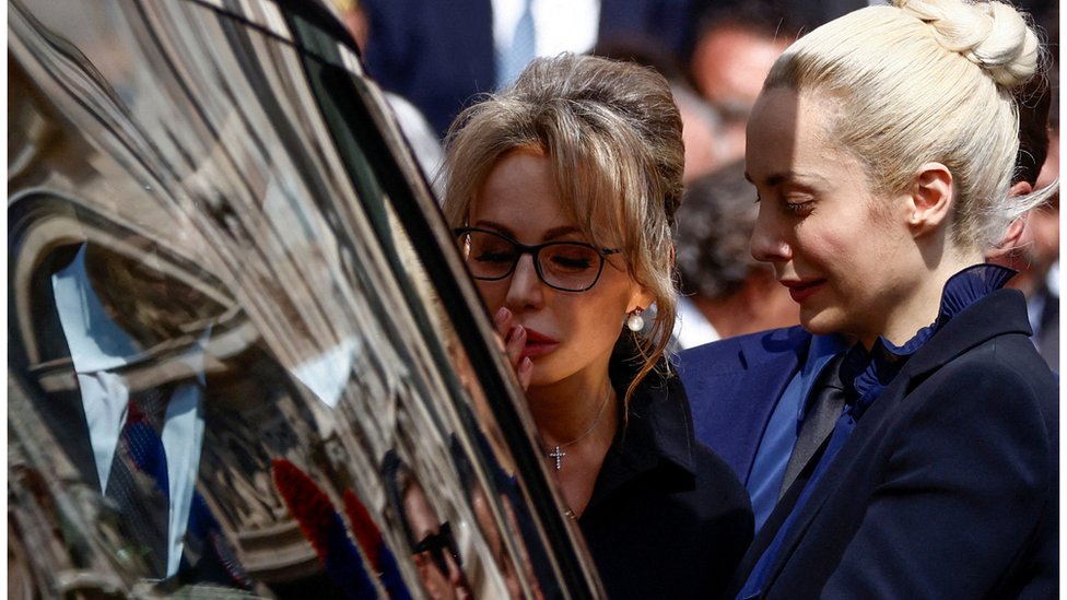 Marina Berlusconi and Marta Fascina react during the state funeral of former Italian Prime Minister Silvio Berlusconi. Seen here partially obscured by the hearse