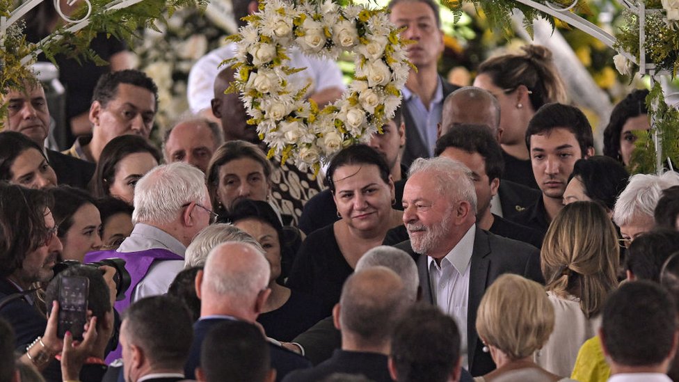 El presidente de Brasil, Luiz Inácio Lula da Silva, rodeado de personas en el funeral.
