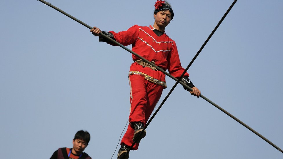 Акробаты выступают на канате в Пекине