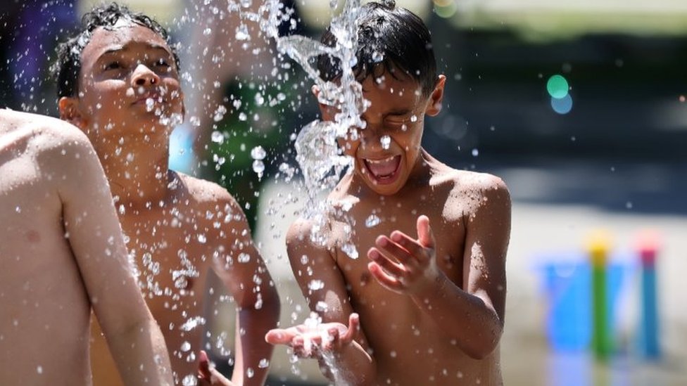 Niños jugando con agua en un parque en Seattle.