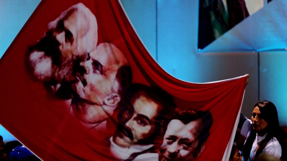 Se esperaba que en el congreso celebrado en Bogotá, la nueva organización de las FARC concretara sus bases ideológicas y decidiera si seguía siendo marxista. Una mujer muestra un cartel con la imagen de algunos de los referentes ideológicos de las FARC, como Marx y Lenin, durante el congreso de la Habana.