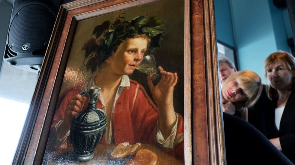 Dr Oetker espera que otras empresas sigan su ejemplo. Visitantes ven la parte trasera de una pintura en una ceremonia en la que se retornaba una pintura robada.