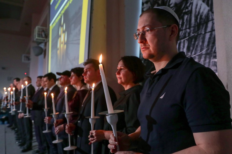 Люди принимают участие в церемонии поминовения жертв Холокоста