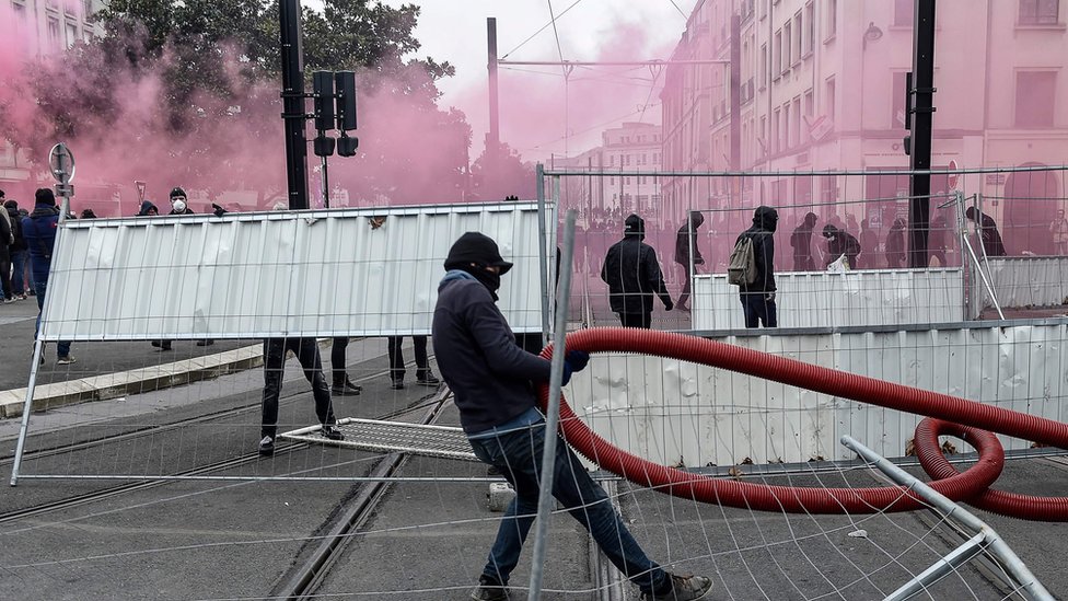 Протестующий в черном идет среди дыма слезоточивого газа во время акции протеста против капитального ремонта пенсионного фонда в Нанте 5 декабря 2019 года.