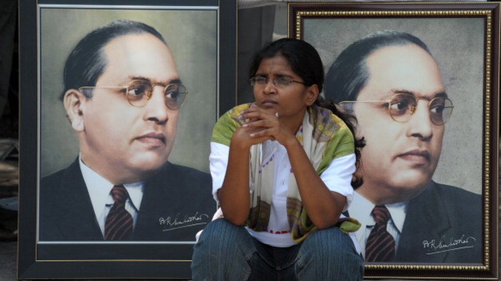 n Indian woman sits infront of portraits of Bhimrao Ramji Ambedkar during 122nd birth anniversary celebrations for Ambedkar in Hyderabad on April 14, 2012.