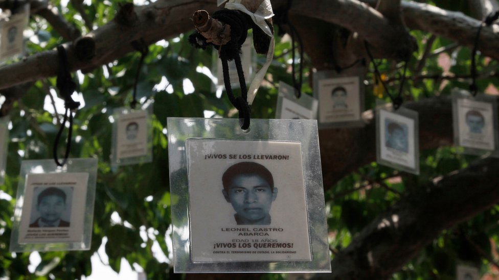 Ламинированные изображения 43 пропавших без вести учеников сельского педагогического колледжа Исидро Бургоса свисают с дерева в Мехико, пятница, 26 августа 2016 г.