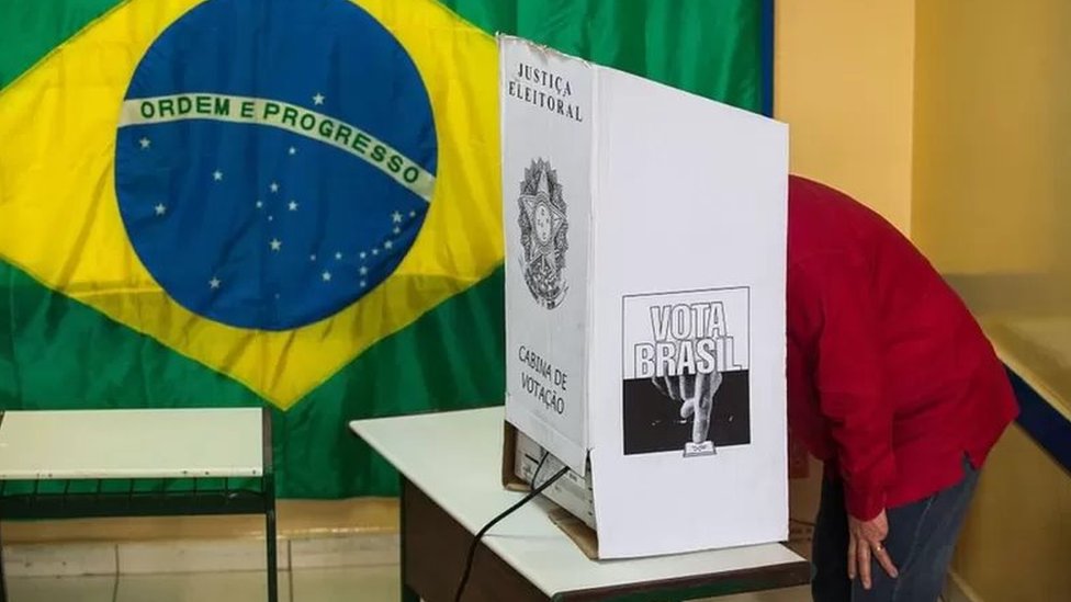 Sala de votação com bandeira do Brasil na parede