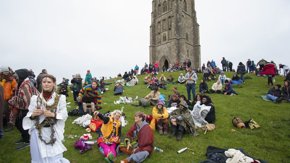 Revellers gather to celebrate the summer solstice on Glastonbury Tor, Somerset,