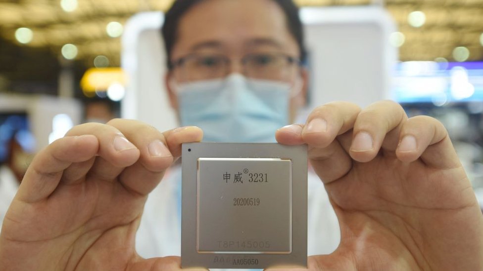 Un empleado de la compañía china Semiconductor Manufacturing Corporation (SMIC) muestra un microship.