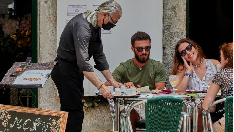 Мужчина подает кофе в Лиссабоне, Португалия