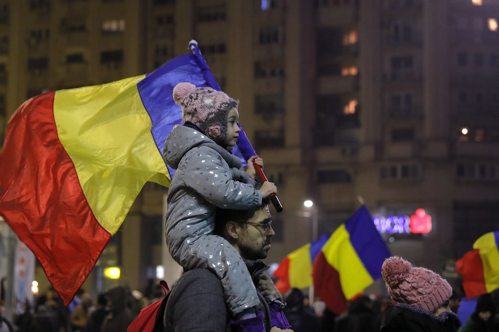 Ребенок несет румынский национальный флаг во время демонстрации в Бухаресте, Румыния, 5 февраля