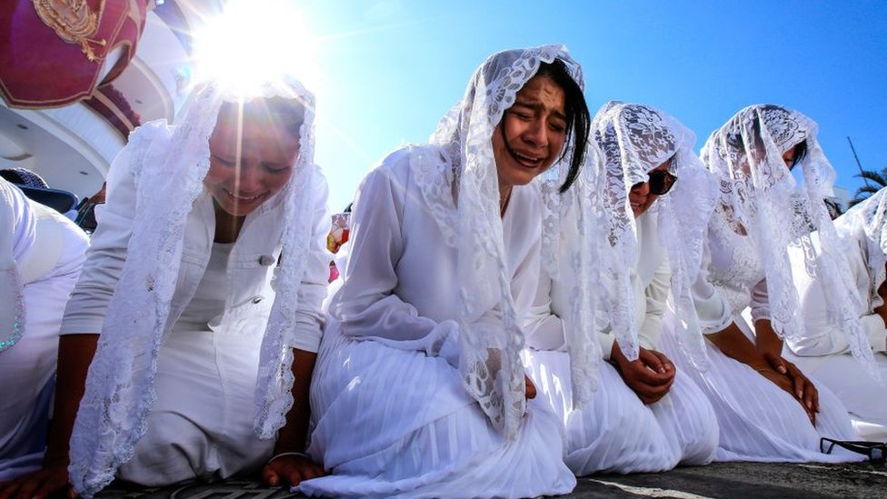 Una fila de jóvenes arrodilladas lloran en una de las misas de La Luz del Mundo en México.