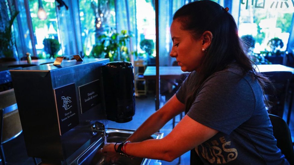 A woman washes her hands at a restaurant in Mexico City, July 2020
