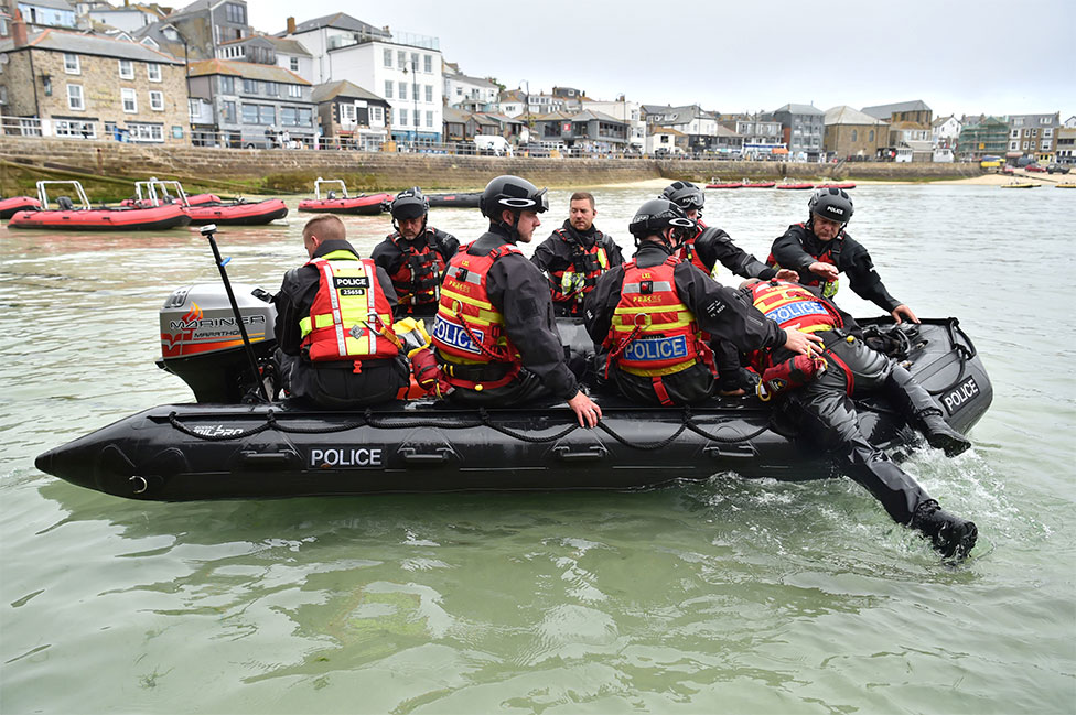 Police officers are seen on a rigid inflatable boat in St Ives in the sea