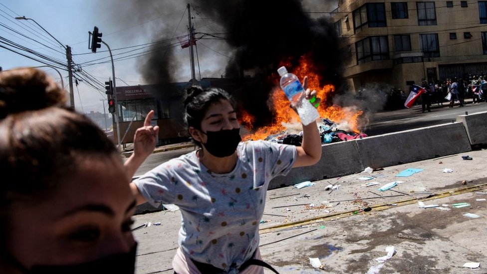 Mujer celebra la quema de ropa de los migrantes