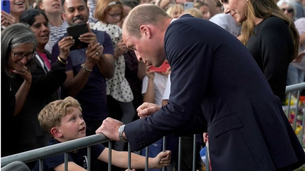 El príncipe William saluda a un niño en el Castillo de Windsor.