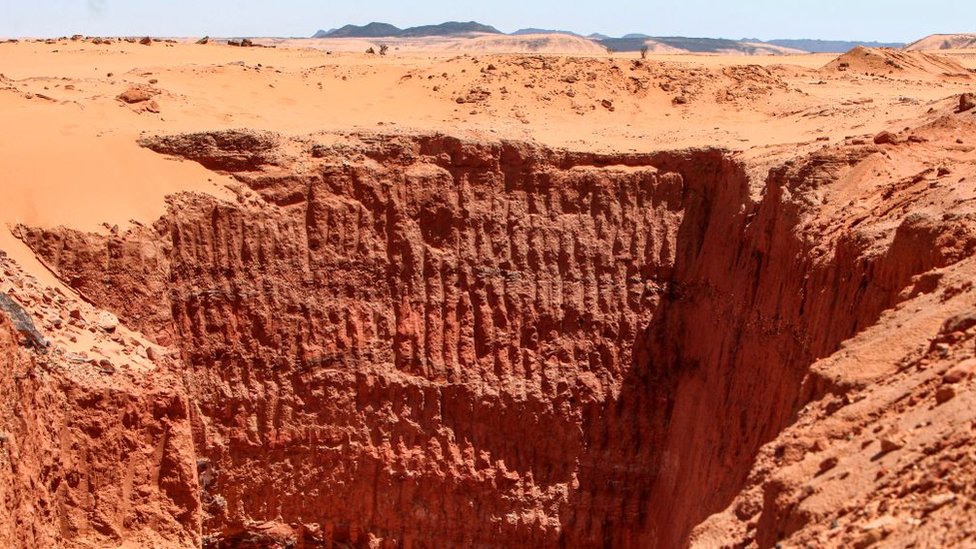 Обширная траншея, выкопанная охотниками за золотом, изображена на опустошенном двух тысячелетнем месте Джабаль Марага в пустыне Байуда