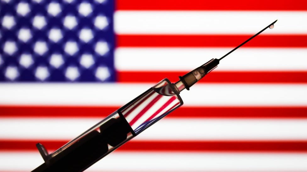 a syringe in front of an American flag