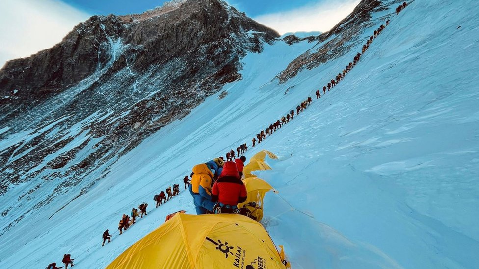 Mountaineers line up as they climb a slope during their ascend to summit Mount Everest in 2001
