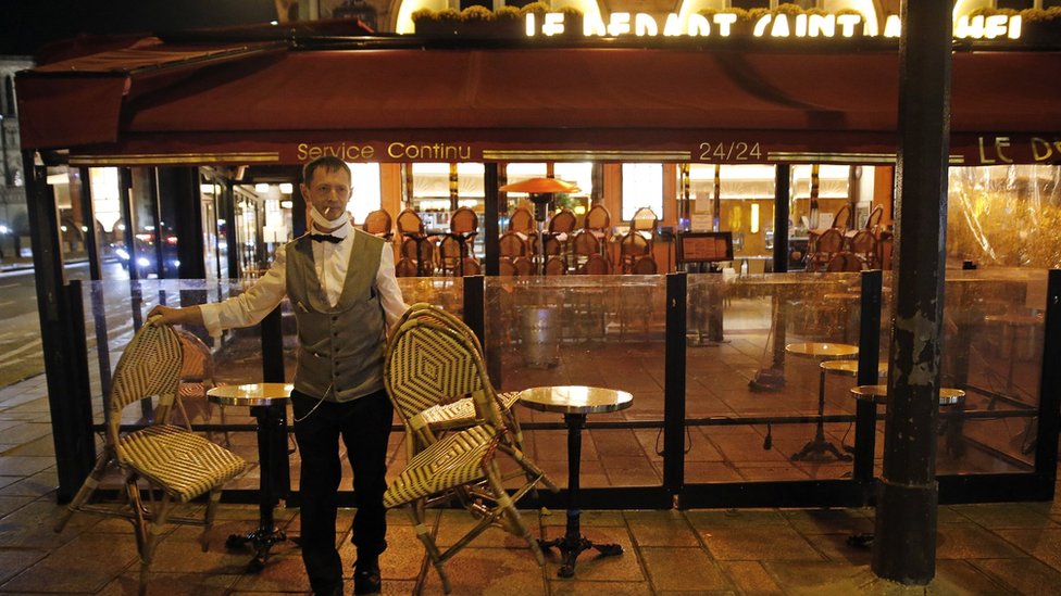 A barman closes his establishment at 9pm as part of a city-wide night time curfew during the coronavirus (COVID-19) pandemic on October 28, 2020 in Paris, France.