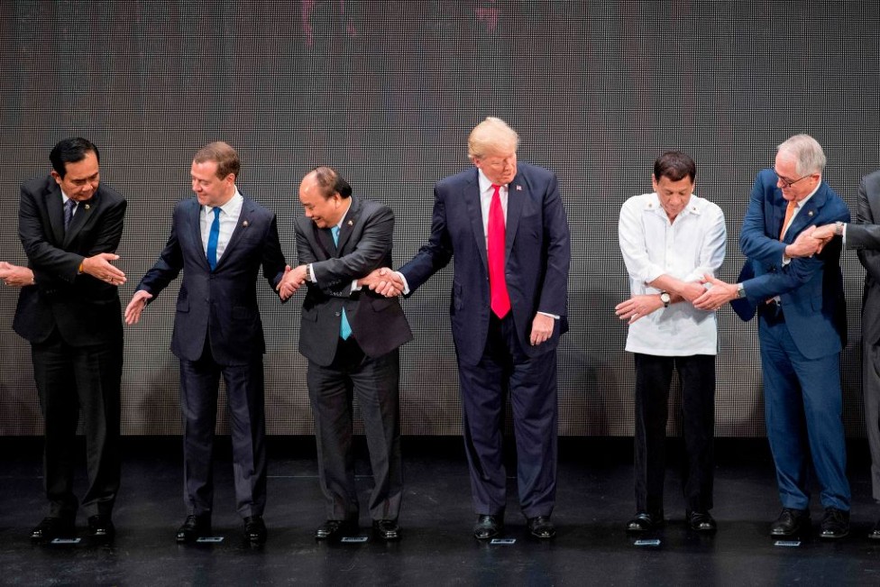El expresidente de Estados Unidos Donald Trump y otros mandatarios cruzando las manos