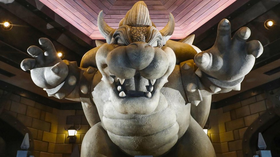 Статуя Баузера с поднятыми руками в пугающей позе в тематическом парке Nintendo
