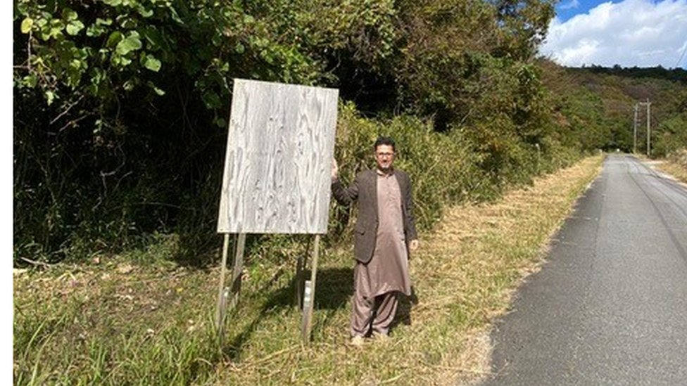 Dr Khan standing in front of land which they bought with the intention of turning it into a graveyard