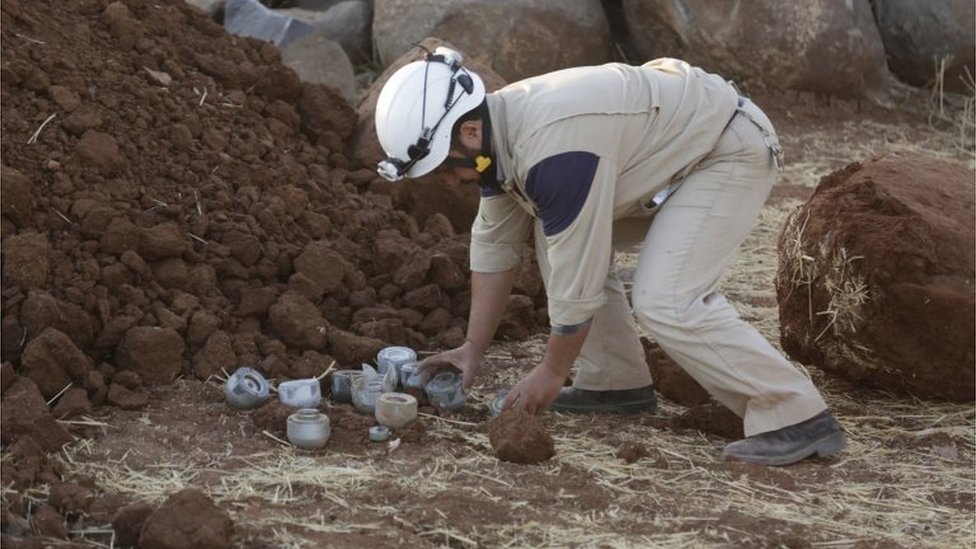 Член гражданской обороны собирает неразорвавшиеся кассетные бомбы, которые, по словам активистов, были выпущены российскими самолетами в Маасране, южная провинция Идлиб.