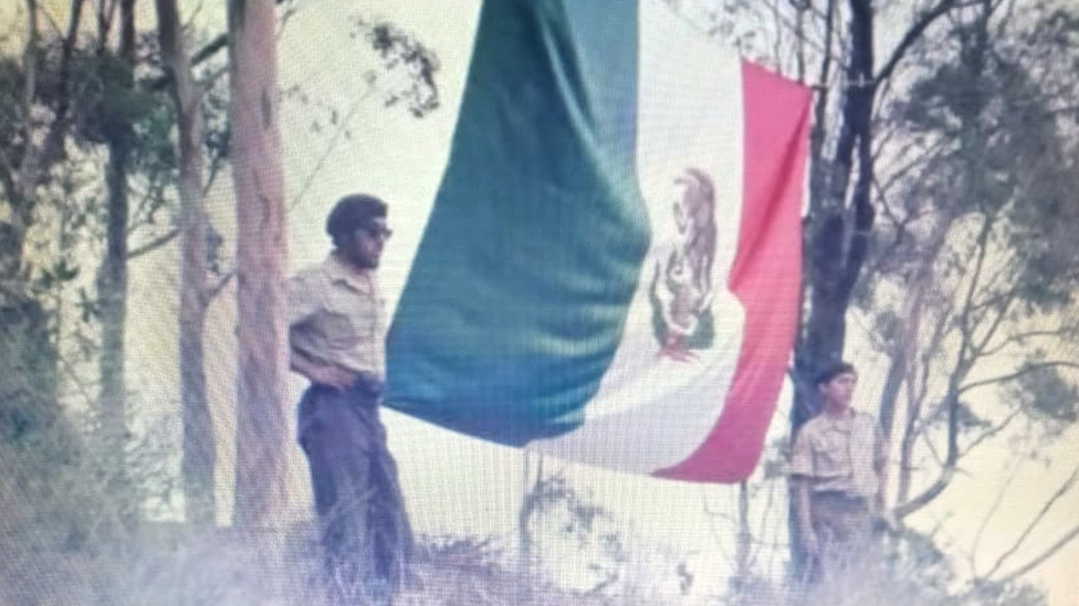 Dos boinas cafés junto a la bandera de México desplegada en Santa Catalina.