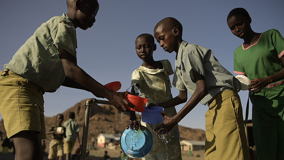 Niños en el norte de Kenia lavan sus bowls con agua de una canilla.