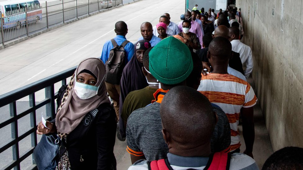 Люди идут по пешеходному мосту в Дар-эс-Саламе, Танзания - 16 апреля 2020 г.